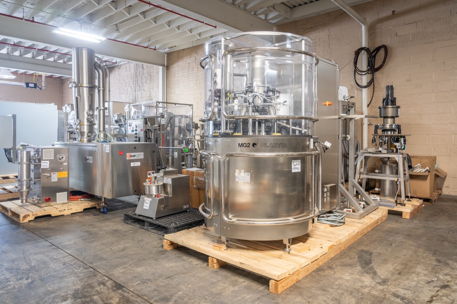 An MG2 Planeta capsule filler and Glatt equipment on the Federal Equipment Company warehouse floor in Cleveland, OH