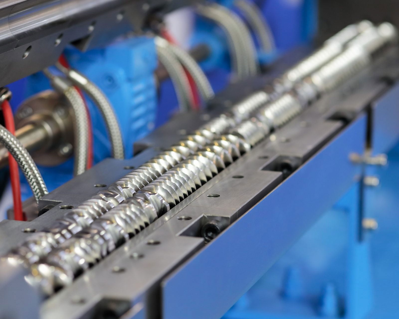 Open barrel of a twin-screw extruder showing its two intermeshing screws