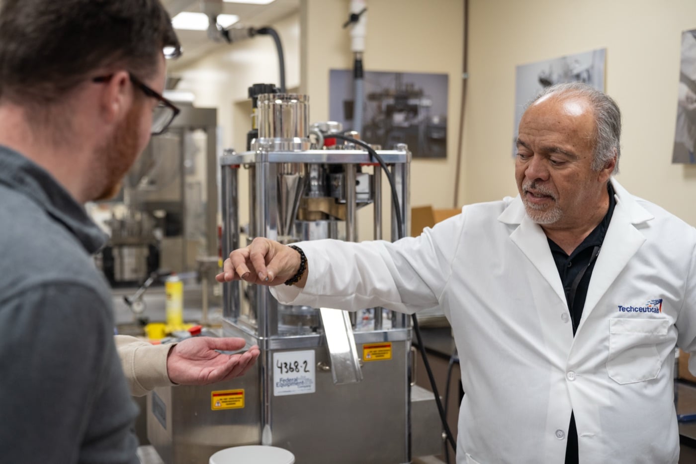 Jesus Lopez, Techceuticals Technical Director, with a trainee at a tablet press in the Techceuticals Training and Development Center in Cleveland, OH